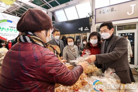 이상일 용인특례시장이 부인 김미영 여사와 용인중앙시장에서 수제 강정을 구입하고 있다.